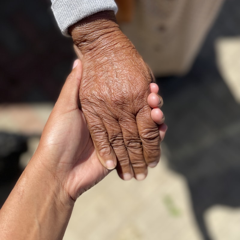 Cuidadora tomando la mano de una persona mayor